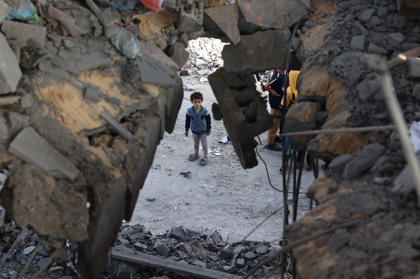 A Palestinian child stands in front of a building destroyed by Israeli bombing in Rafah in the southern Gaza Strip on May 3, 2024. (AFP Photo)