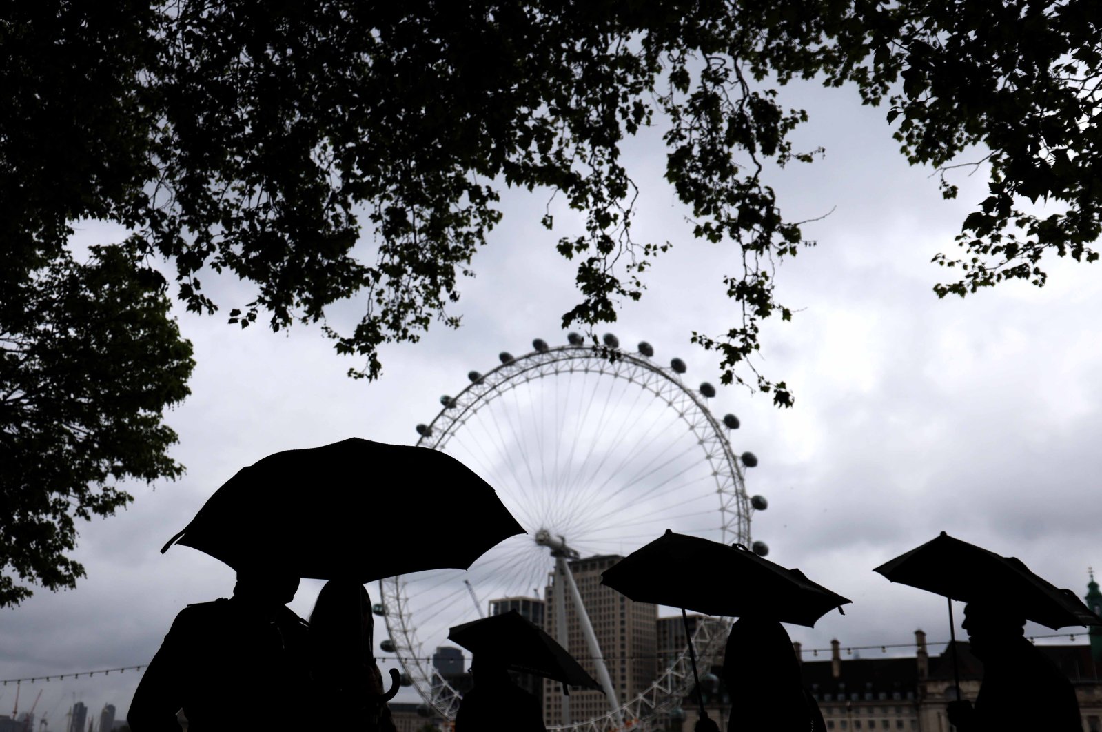 People walk on a rainy day near the London Eye Ferris wheel in London, Britain, May 4, 2024. (EPA Photo)