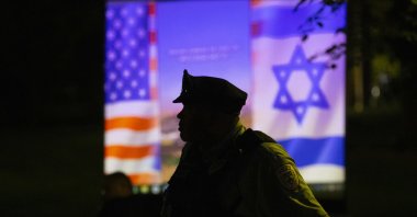 A Philadelphia police officer is silhouetted against a projected presentation on Hamas being shown by a pro-Israel group during a protest at Penn, in Philadelphia, U.S., May 2, 2024. (AP Photo)