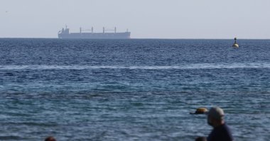 People enjoy the beach as a cargo ship sails in the background, near the Red Sea port of Eilat, southern Israel, April 16, 2024. (EPA Photo)