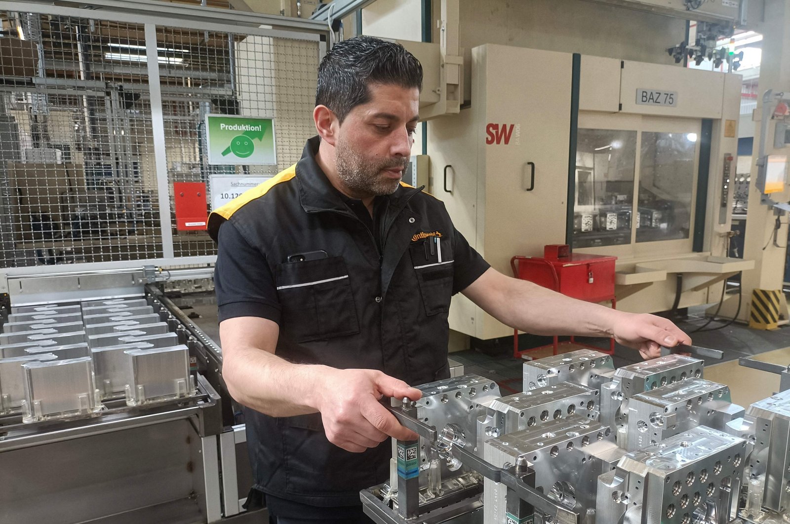 Emrullah Karaca checks hydraulic valve blocks at his workplace at the  Continental Automotive Technologies&#039; plant, Gifhorn, Germany, April 23, 2024. (AFP Photo)