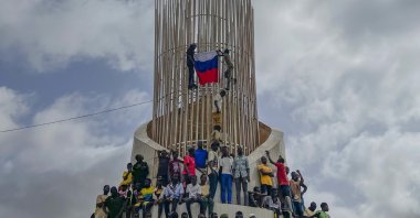 Supporters of Niger's ruling junta hold a Russian flag at the start of a protest called to fight for the country's freedom and push back against foreign interference in Niamey, Niger, Aug. 3, 2023. (AP Photo)
