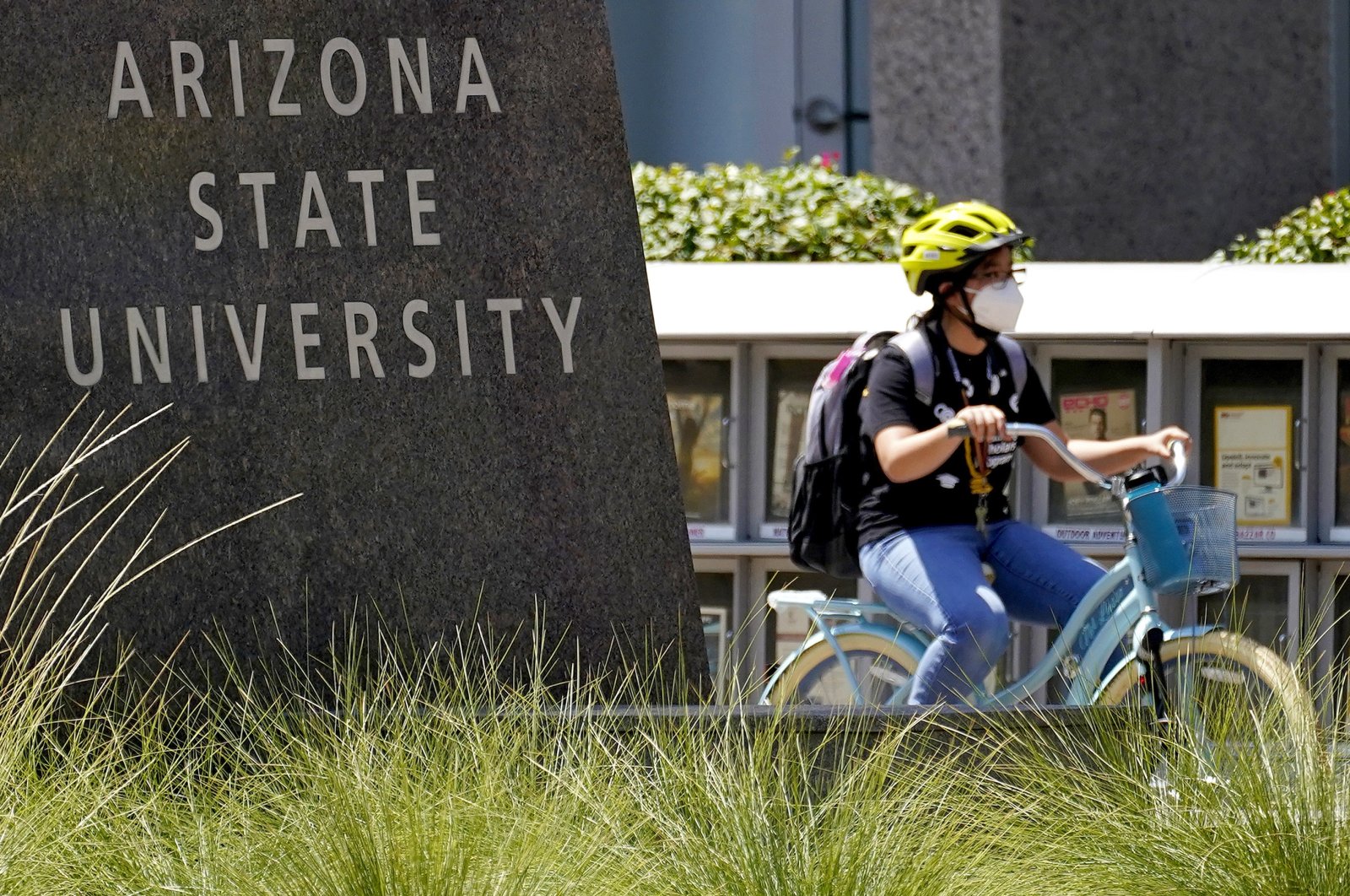 A cyclist crosses an intersection on the campus of Arizona State University, in Tempe, Arizona, Sept. 1, 2020. (AP Photo)
