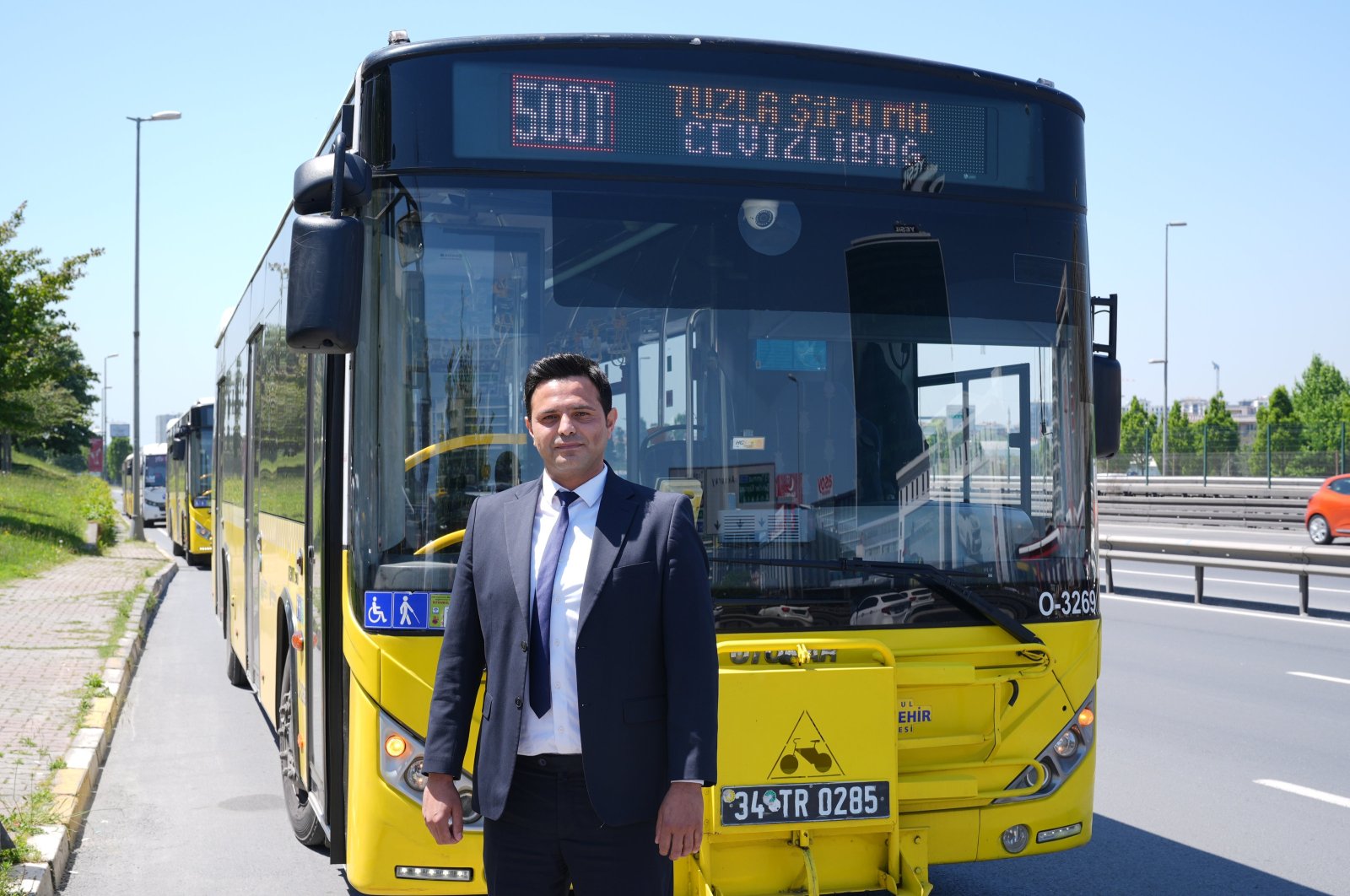 Bus driver Kerem Temur poses in front of a 500T bus in Istanbul, May 7, 2024. (AA Photo)