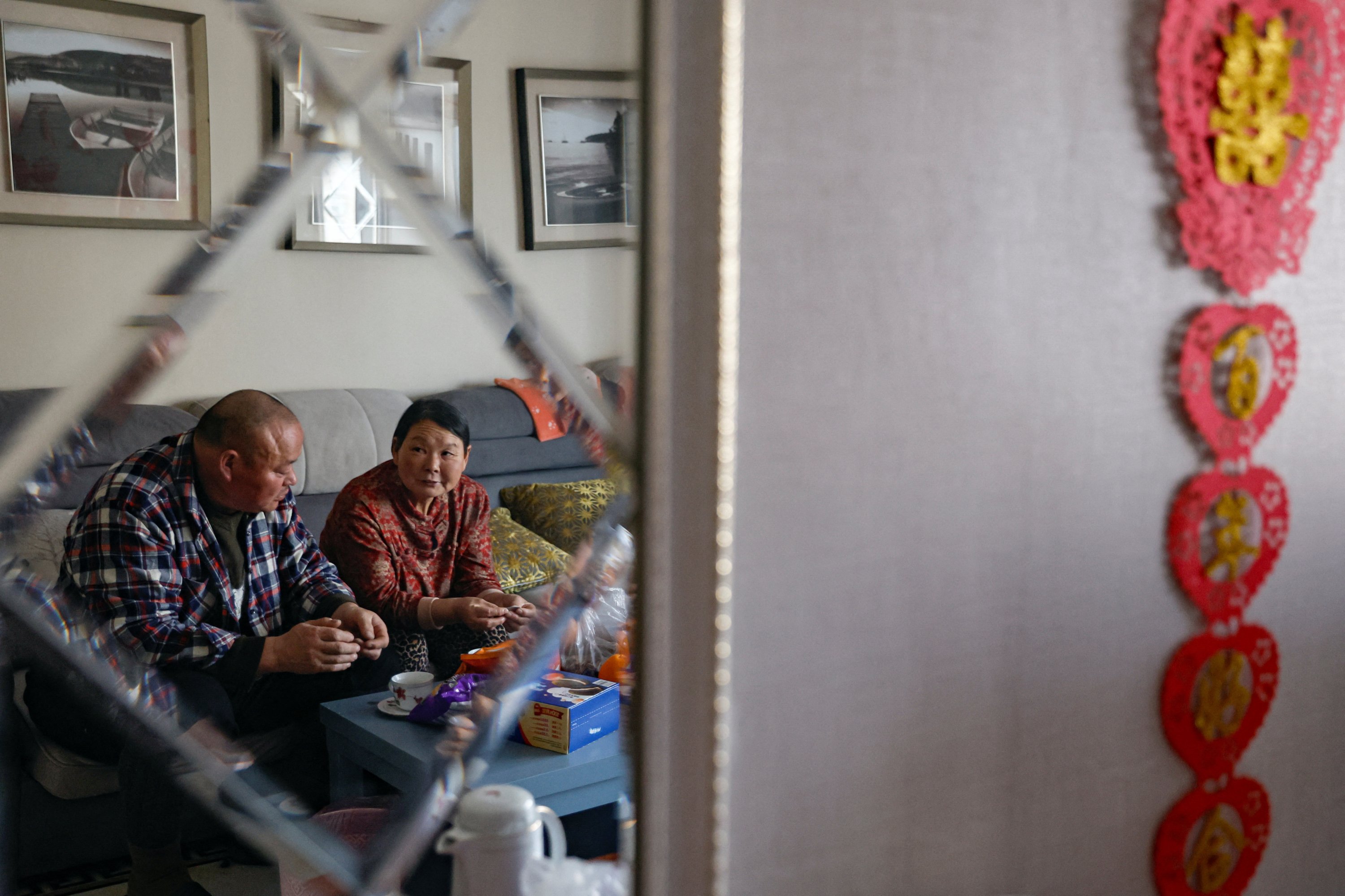 Wu Yonghou, 58, and his wife Yang Chengrong, 60, rest on the sofa after a meal on Chinese Lunar New Year's Eve, at their apartment in a town bordering Beijing, Hebei province, China, Feb. 9, 2024. (Reuters Photo)