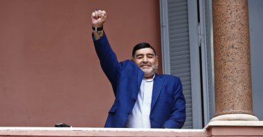 Diego Maradona acknowledges fans below at the Casa Rosada government house after his meeting with Argentine President Alberto Fernandez, Buenos Aires, Argentina, Dec. 26, 2019. (AP Photo)