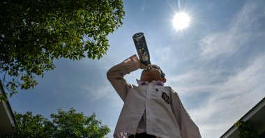 A student drinks water while studying outside the classroom during a heatwave in Banda Aceh, Indonesia, May 7, 2024. (AFP Photo)