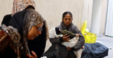A Palestinian girl carries a baby as she mourns people killed by Israeli strikes, Rafah, southern Gaza, Palestine, May 8, 2024. (Reuters Photo)