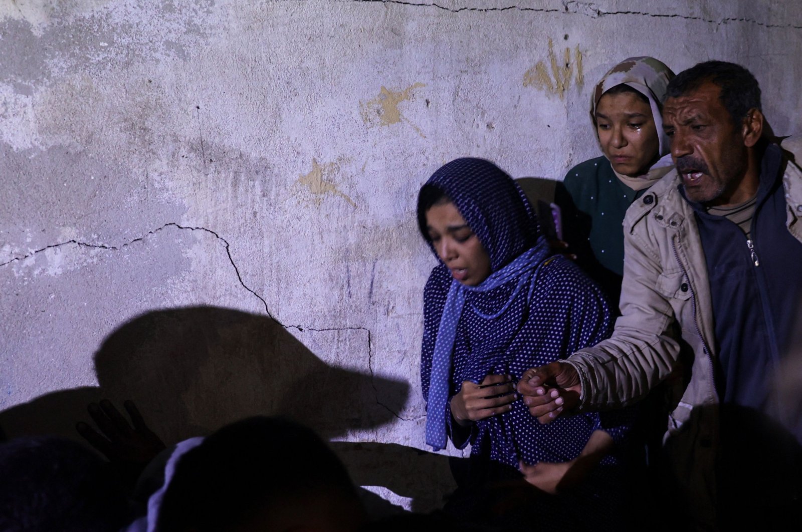 Palestinian family members gather around a wounded relative (not pictured) as civil defense teams help rescue victims from the destroyed al-Qadri family home struck by Israeli bombardment, Rafah, southern Gaza Strip, Palestine, May 7, 2024. (AFP Photo)