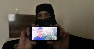 Fatima Ahmed shows the photo of her son kidnapped by the PKK terrorist organization, Aleppo, Syria, May 9, 2024. (AA Photo)