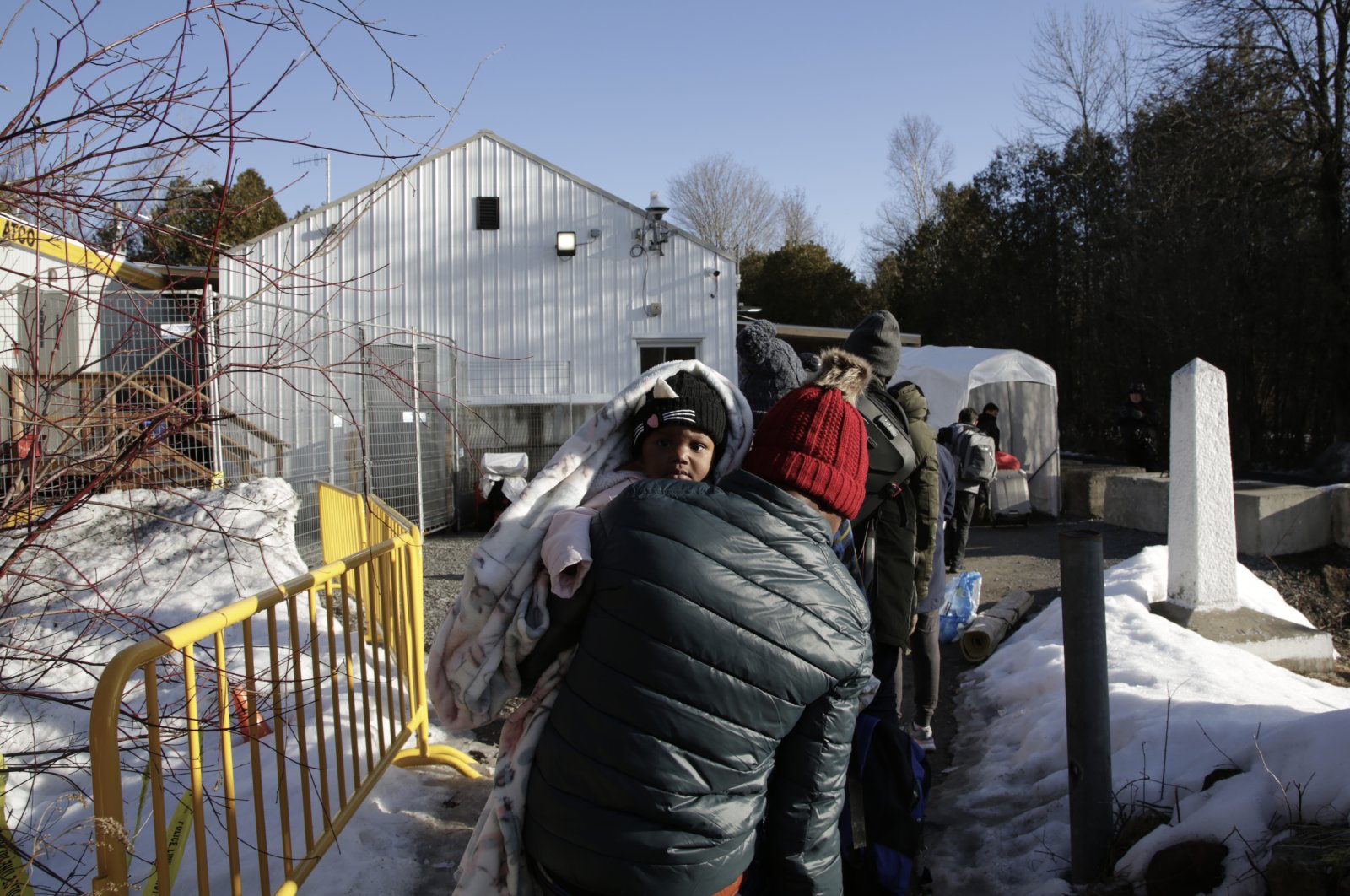 Haitian and Afghani asylum-seekers illegally cross into Canada where police took them into custody at the non-official Roxham Road border crossing, Champlain, New York, March 24, 2023. (AP Photo)