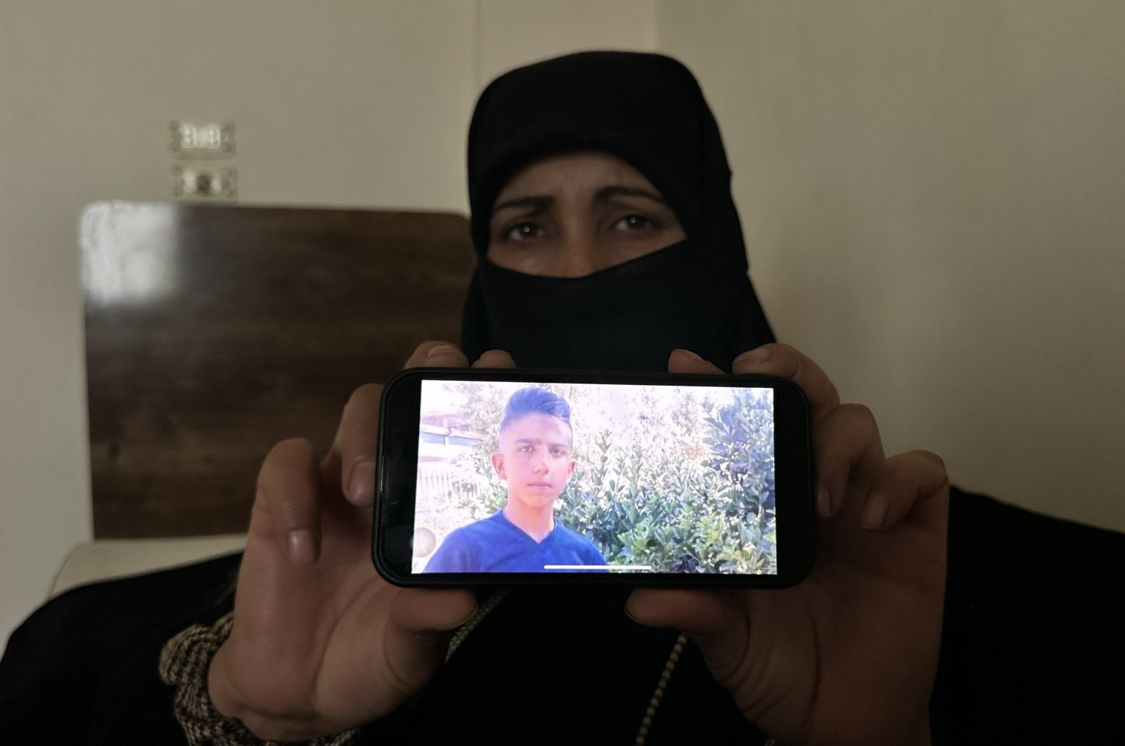 Fatima Ahmed shows the photo of her son kidnapped by the PKK terrorist organization, Aleppo, Syria, May 9, 2024. (AA Photo)