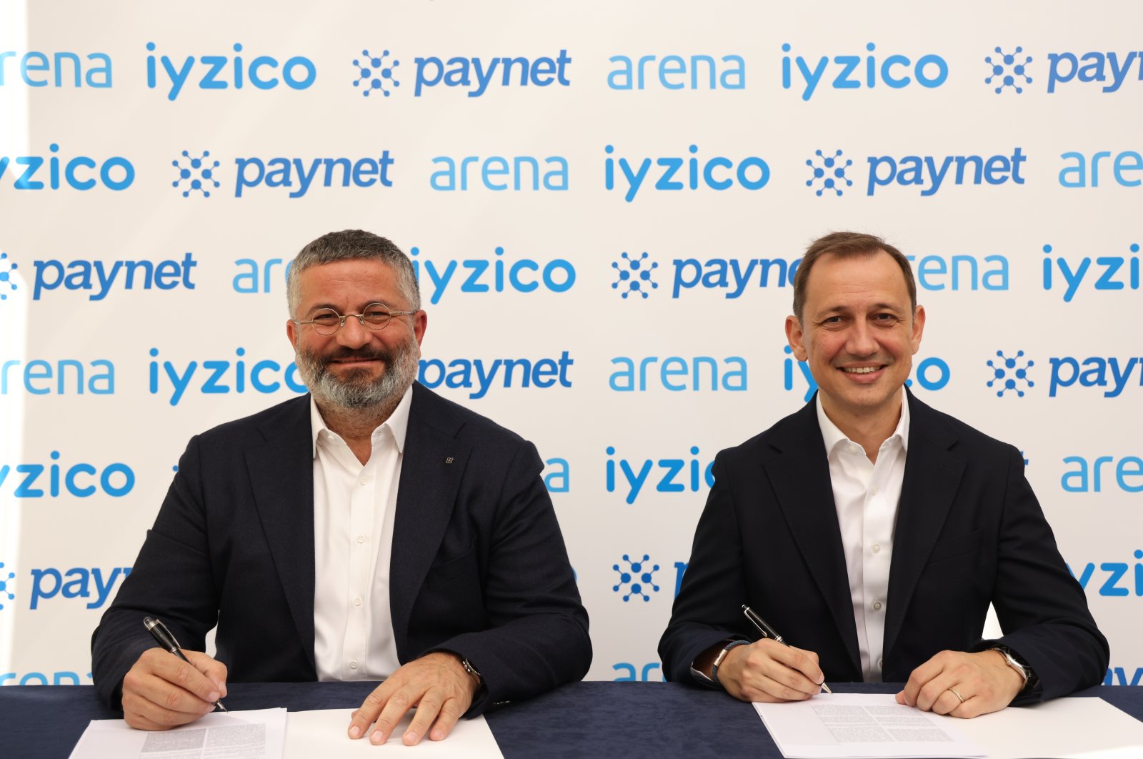 Orkun Saitoğlu (R), CEO of iyzico, signs an agreement with Arena Group CEO Serkan Çelik for the acquisition of Paynet. (Courtesy of iyzico)