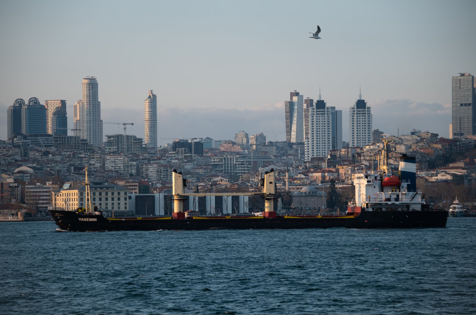 A cargo ship passes through the Bosporus with skyscrapers in the background in Istanbul, Türkiye, Jan. 15, 2023. (Reuters Photo)