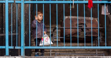 A Palestinian boy stands behind the railings at a nearly deserted school used as a shelter, in Rafah, in the southern Gaza Strip, Palestine, May 13, 2024. (Reuters Photo)