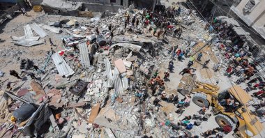 Palestinians gather as rescuers search for casualties trapped under the rubble of of a house hit in an Israeli strike, Gaza, Palestine, May 14, 2024. (Reuters Photo)