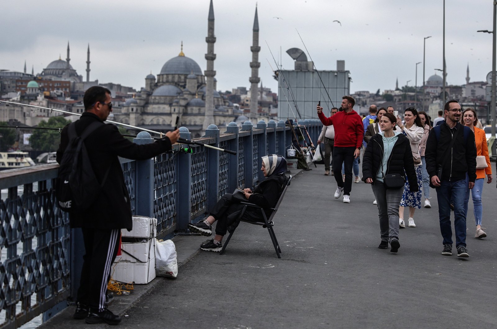 People walk on the Galata Bridge backdropped by the Eminönü New Mosque, Istanbul, Türkiye, May 9, 2024. (EPA Photo)