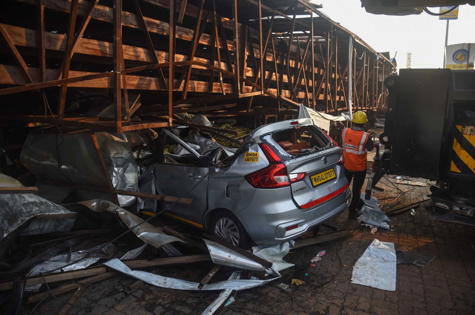 A vehicle is seen crushed under an advertisement billboard that collapsed at a petrol station following a storm, in Mumbai, India, May 14, 2024. (AFP Photo)