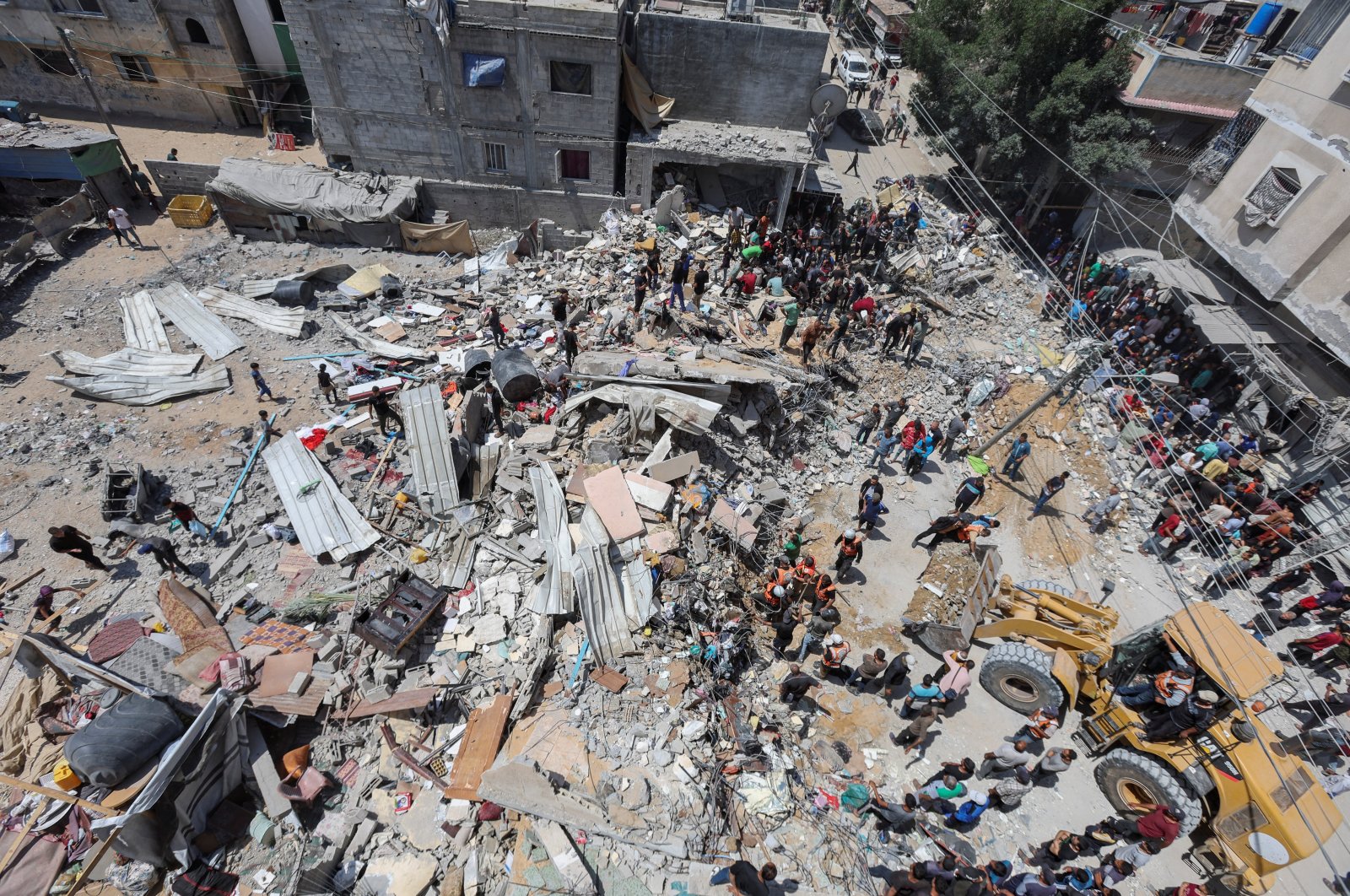 Palestinians gather as rescuers search for casualties trapped under the rubble of of a house hit in an Israeli strike, Gaza, Palestine, May 14, 2024. (Reuters Photo)