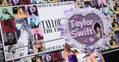 A Taylor Swift fan takes a picture of a handmade sign next to the poster of Taylor Swift's "Eras Tour" first concert in Europe, at the Paris La Defense Arena, Nanterre, Paris, France, May 9, 2024. (EPA Photo)