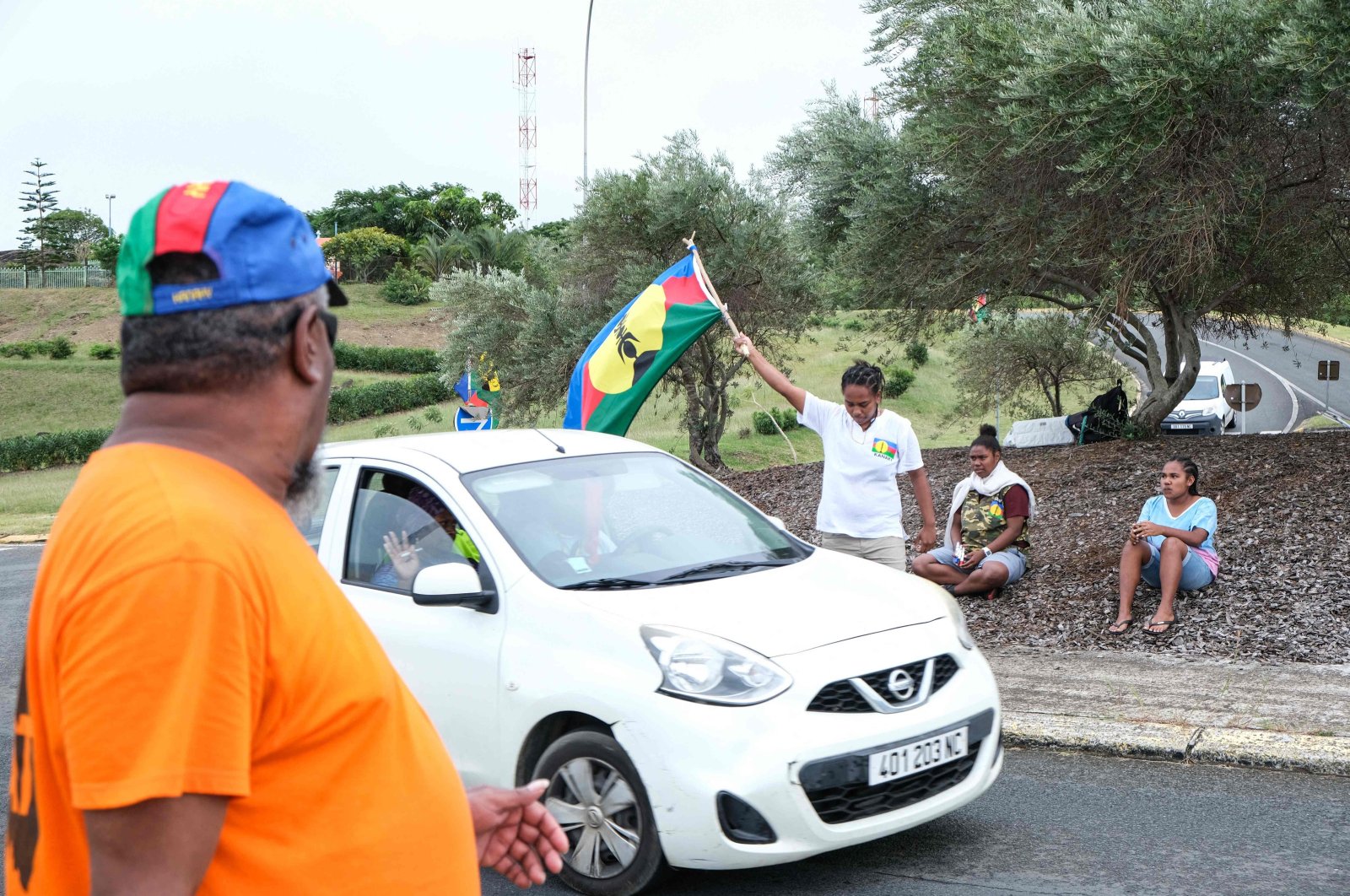 A protester waves a flag of the Socialist Kanak National Liberation Front (FLNKS) at a vehicle checkpoint in Noumea, New Caledonia, May 15, 2024. (AFP Photo)