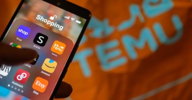The Temu app icon is being displayed on a smartphone with a Temu package visible in the background in this photo illustration in Brussels, Belgium, April 1, 2024. (Reuters Photo)