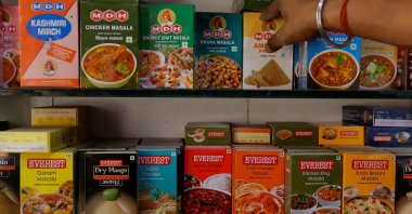 A man adjusts the spice boxes of MDH and Everest on the shelf of a shop at a market in New Delhi, India, April 29, 2024. (Reuters Photo)