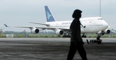 A GMF AeroAsia employee walks past a Garuda Indonesia Boeing 747 aircraft on the tarmac at GMF AeroAsia&#039;s hangar, Tangerang, Indonesia, Jan. 12, 2011. (Reuters File Photo)