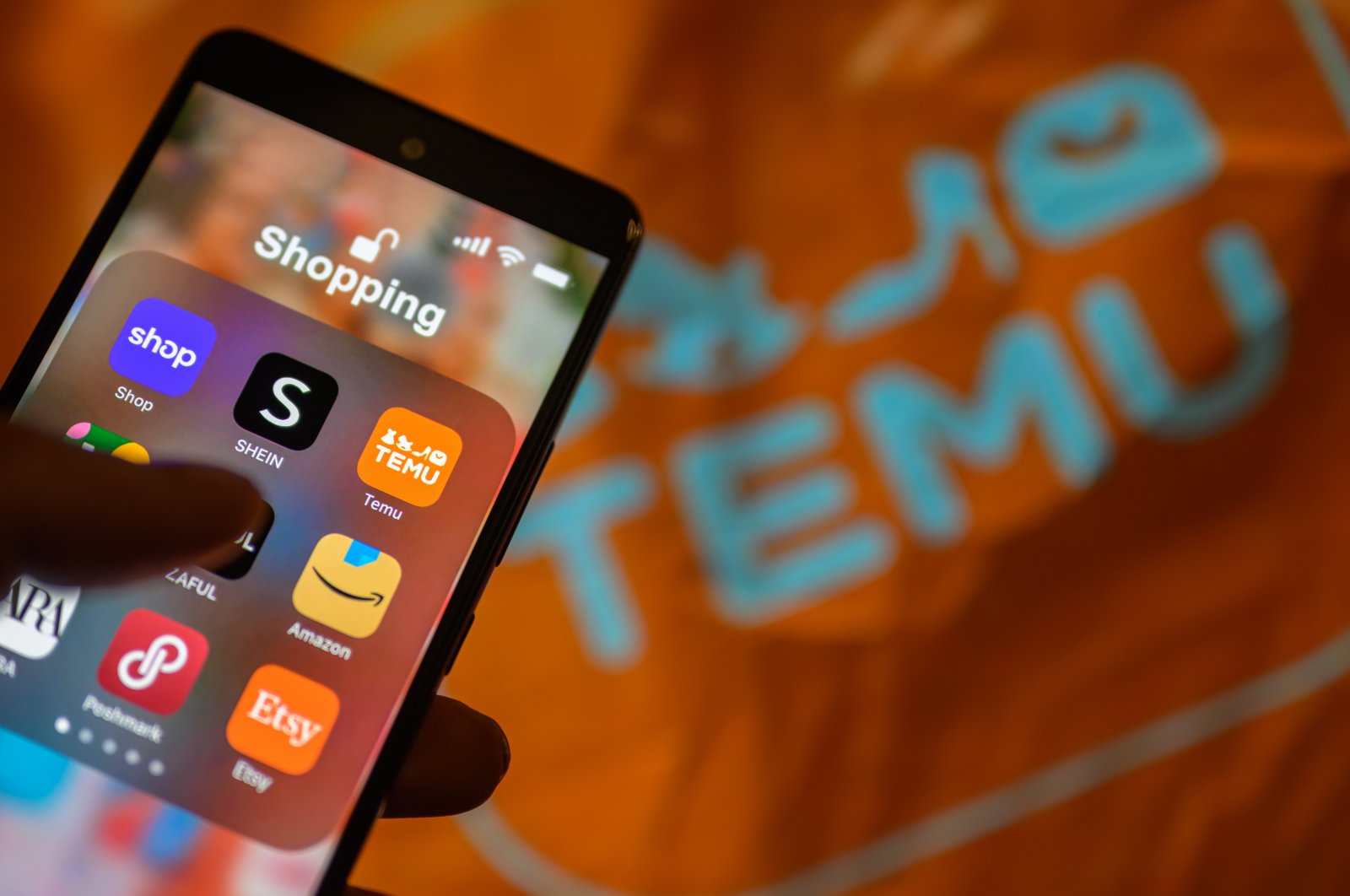 The Temu app icon is being displayed on a smartphone with a Temu package visible in the background in this photo illustration in Brussels, Belgium, April 1, 2024. (Reuters Photo)