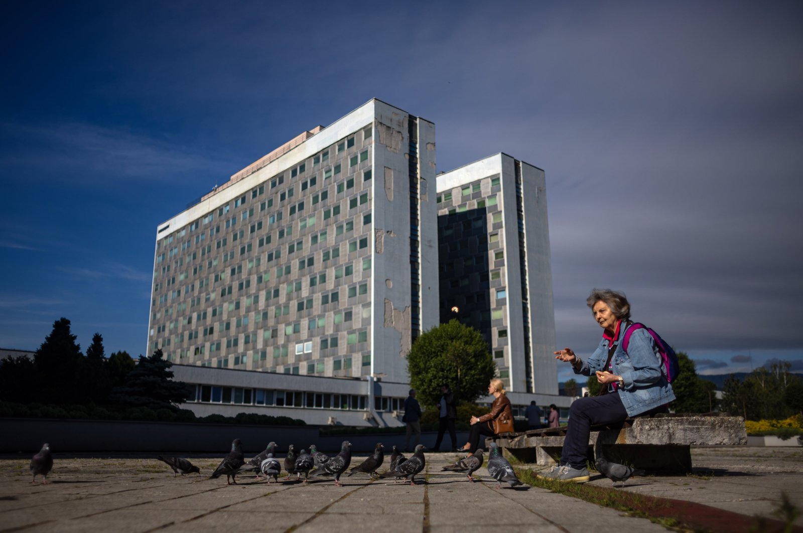 A woman feeds pigeons outside the F. D. Roosevelt University Hospital, where Slovak Prime Minister Robert Fico is being treated, Banska Bystrica, Slovakia, May 16, 2024. (EPA Photo)