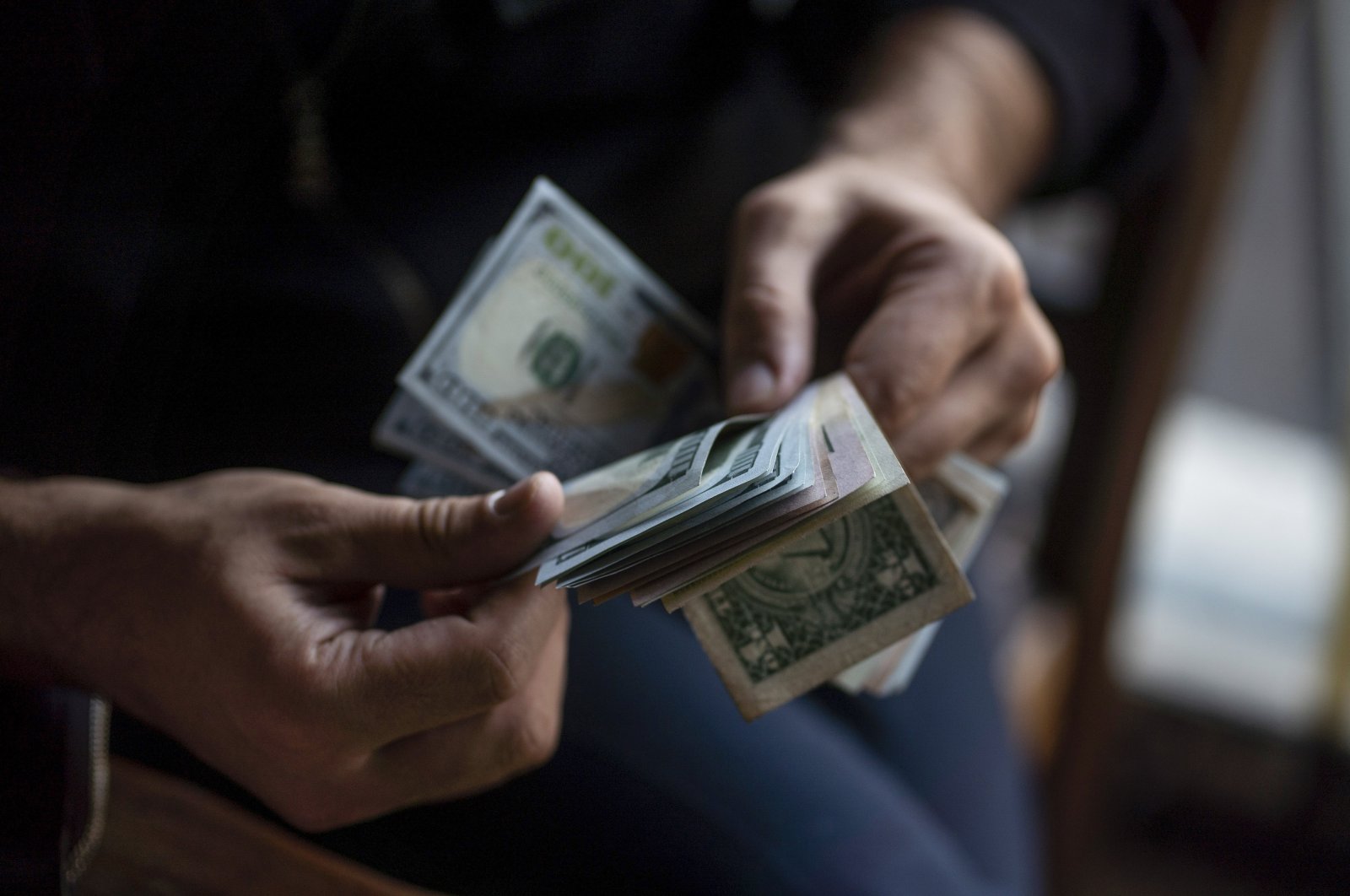 A person counts U.S. dollar banknotes. (Getty Images Photo)