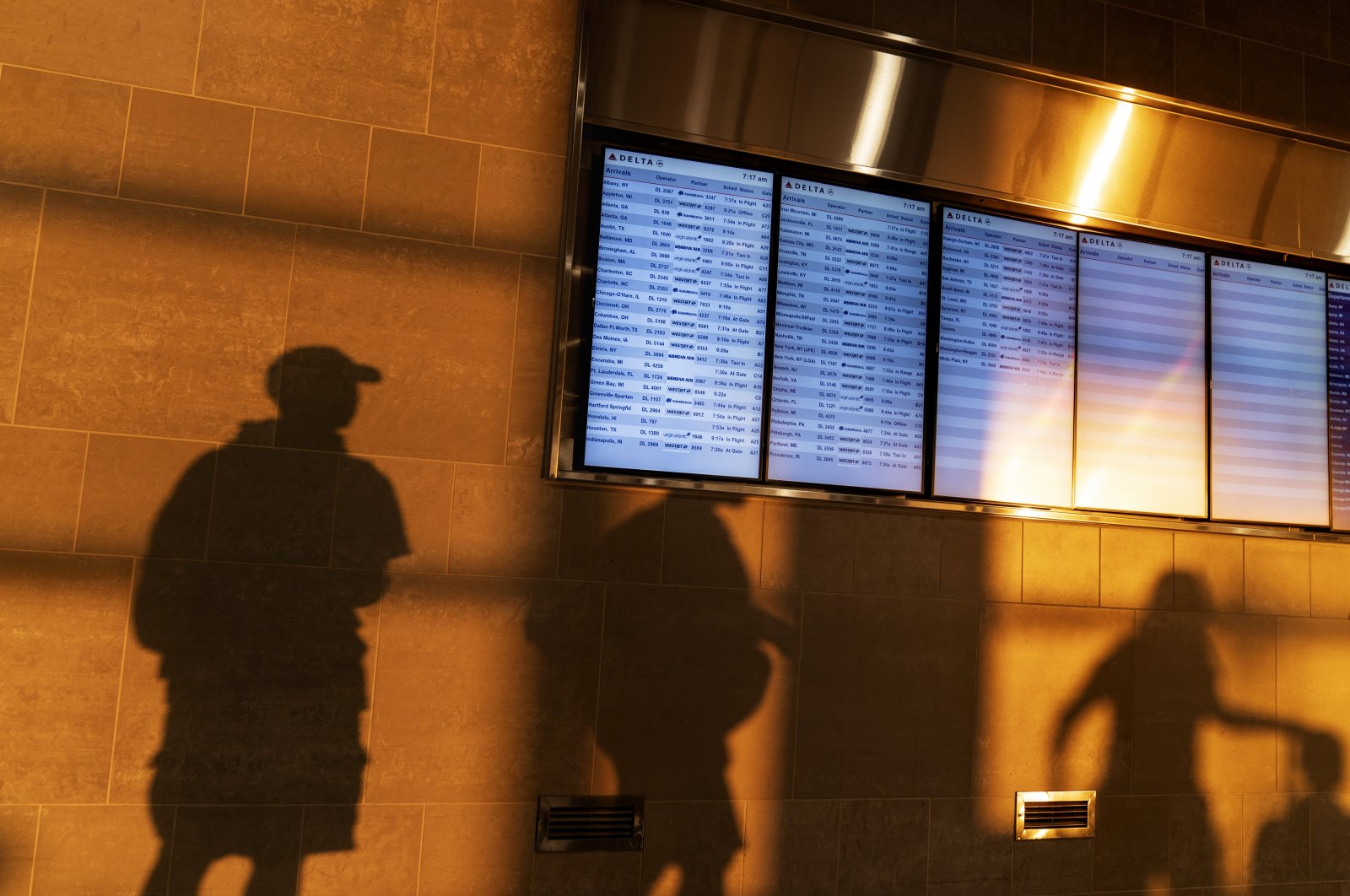 The shadows of air travelers are cast around information screens at Detroit Metropolitan Airport, U.S., Sept. 4, 2023. (AP File Photo)