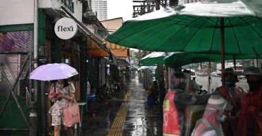 A woman carries an umbrella to shelter from heavy rain along a street in Bangkok, Thailand, May 16, 2024. (AFP Photo)
