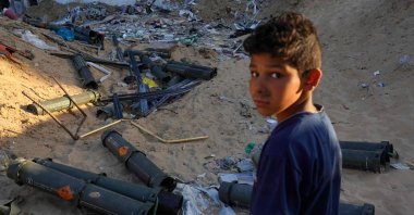 A Palestinian boy stands next to empty U.S. ammunition containers in Khan Yunis in the southern Gaza Strip, May 16, 2024. (AFP Photo)