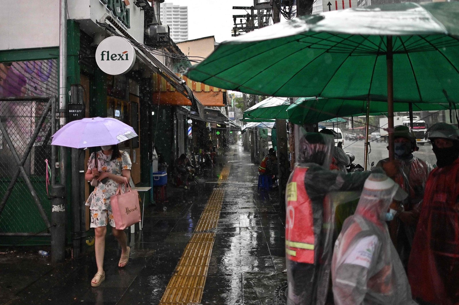 A woman carries an umbrella to shelter from heavy rain along a street in Bangkok, Thailand, May 16, 2024. (AFP Photo)