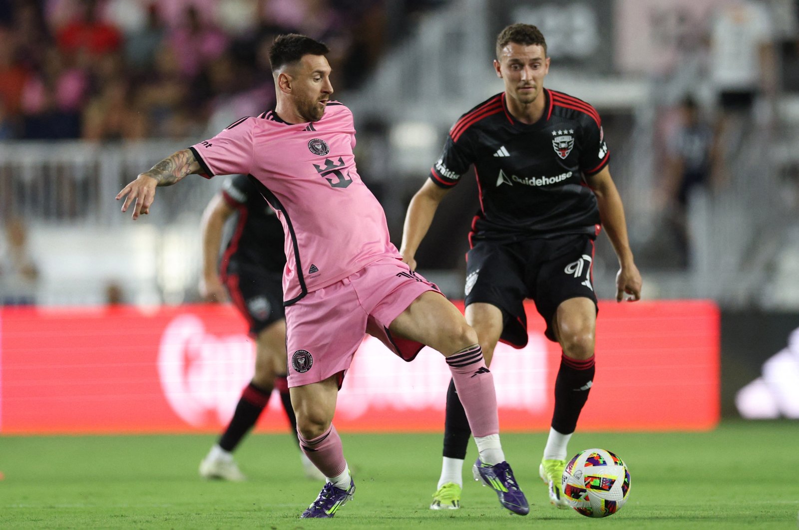 Inter Miami Lionel Messi (L) controls the ball against D.C. United defender Christopher McVey in the first half at Chase Stadium, Fort Lauderdale, Florida, U.S., May 18, 2024. (Reuters Photo)