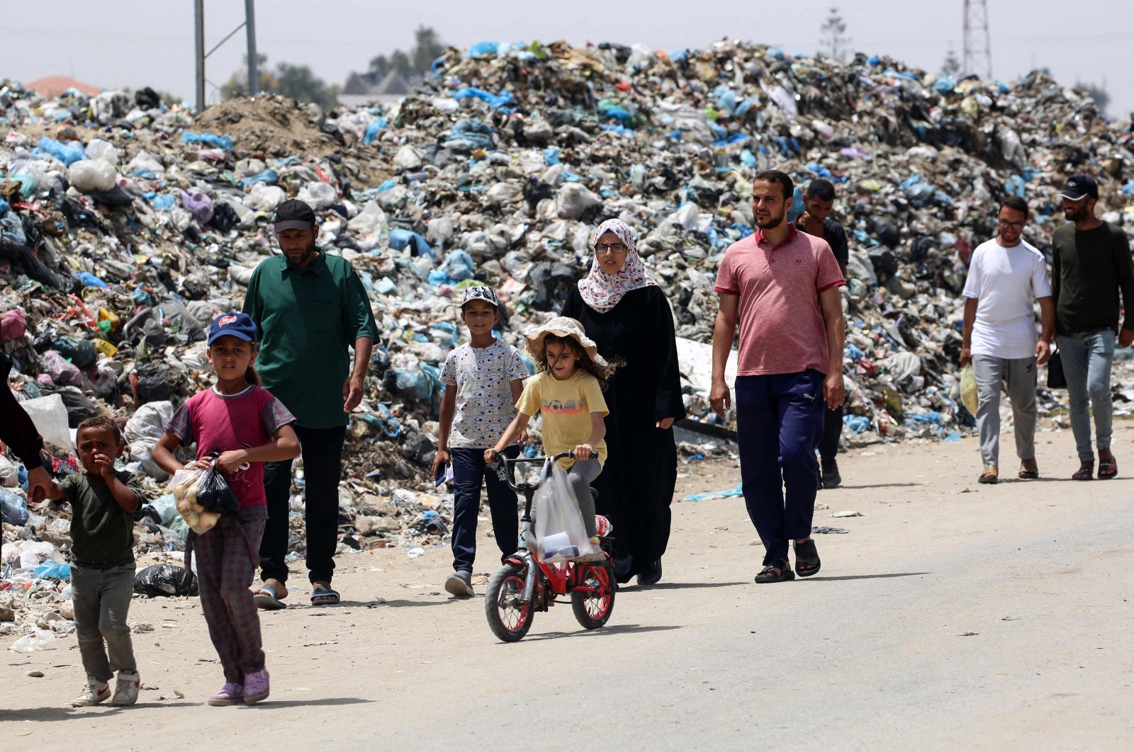 Displaced Palestinians walk past garbage piled up near tents in Khan Younis, in the southern Gaza Strip, Palestine, May 18, 2024. (AFP Photo)