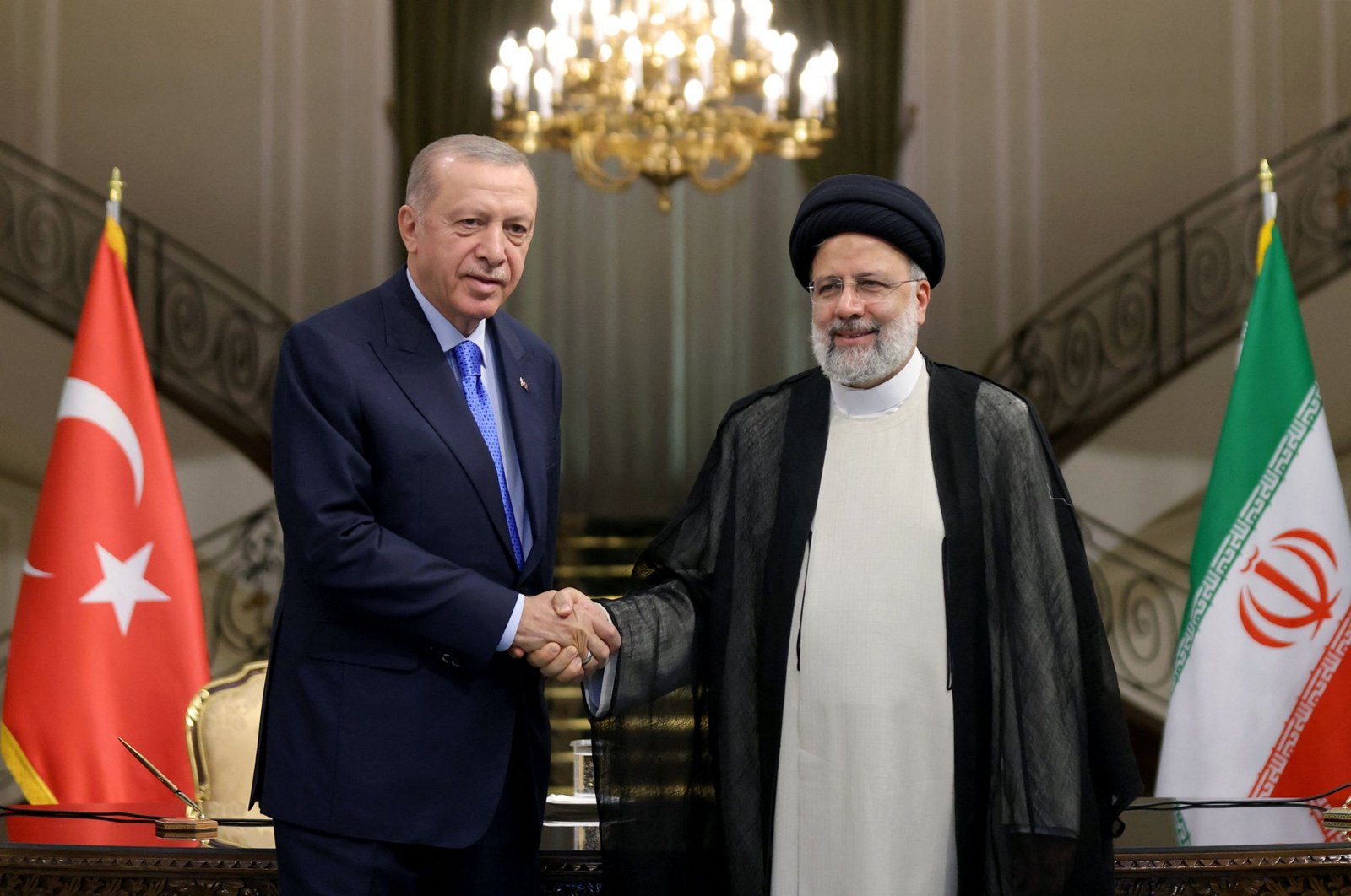 President Recep Tayyip Erdoğan (L) shakes hands with Iranian President Ebrahim Raisi, in Tehran, Iran, July 19, 2022. (AFP Photo)