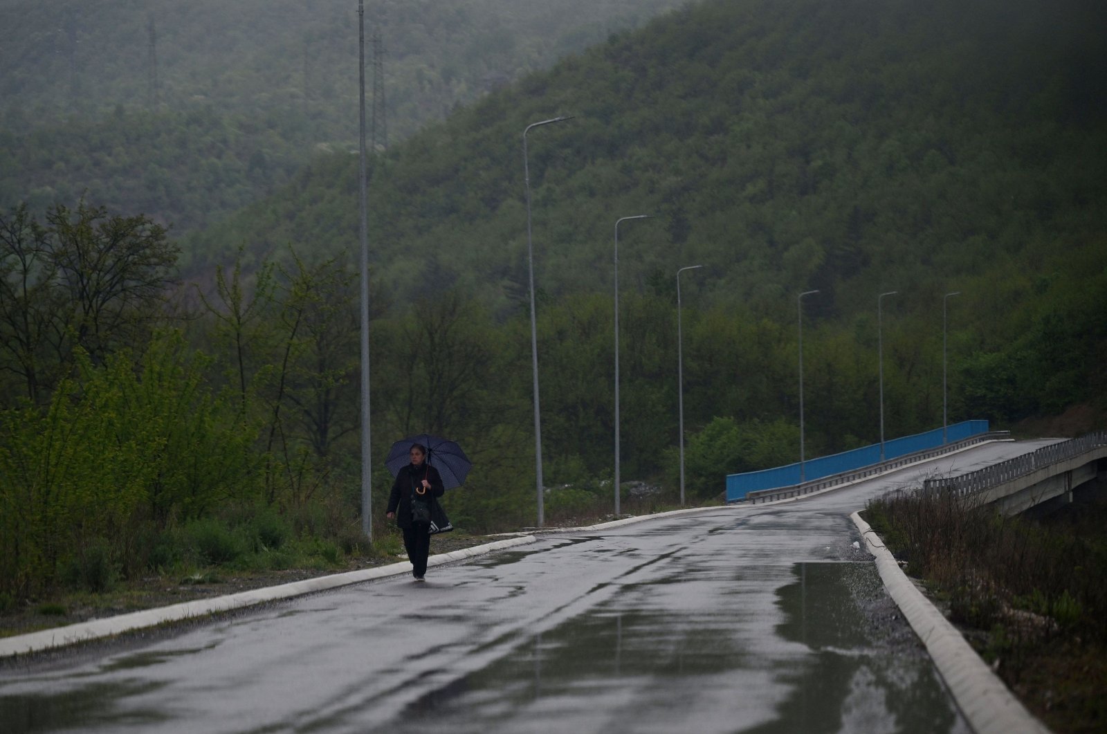 A Kosovo Serb woman crosses a bridge near the Serb-majority town of Zvecan, on April 21, 2024. (AFP Photo)
