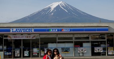 Chinese tourists pose for photos of Mount Fuji appearing over a convenience store in Fujikawaguchiko town, Yamanashi Prefecture, Japan, May 21, 2024. (Reuters Photo)
