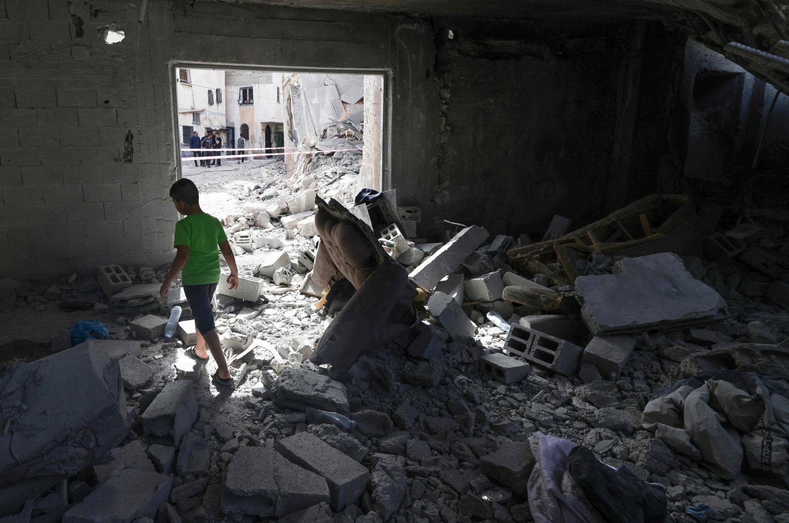 A Palestinian child walks amid the rubble of a building hit by an overnight Israeli strike in the Jenin refugee camp, occupied West Bank, Palestine, May 18, 2024. (AFP Photo)