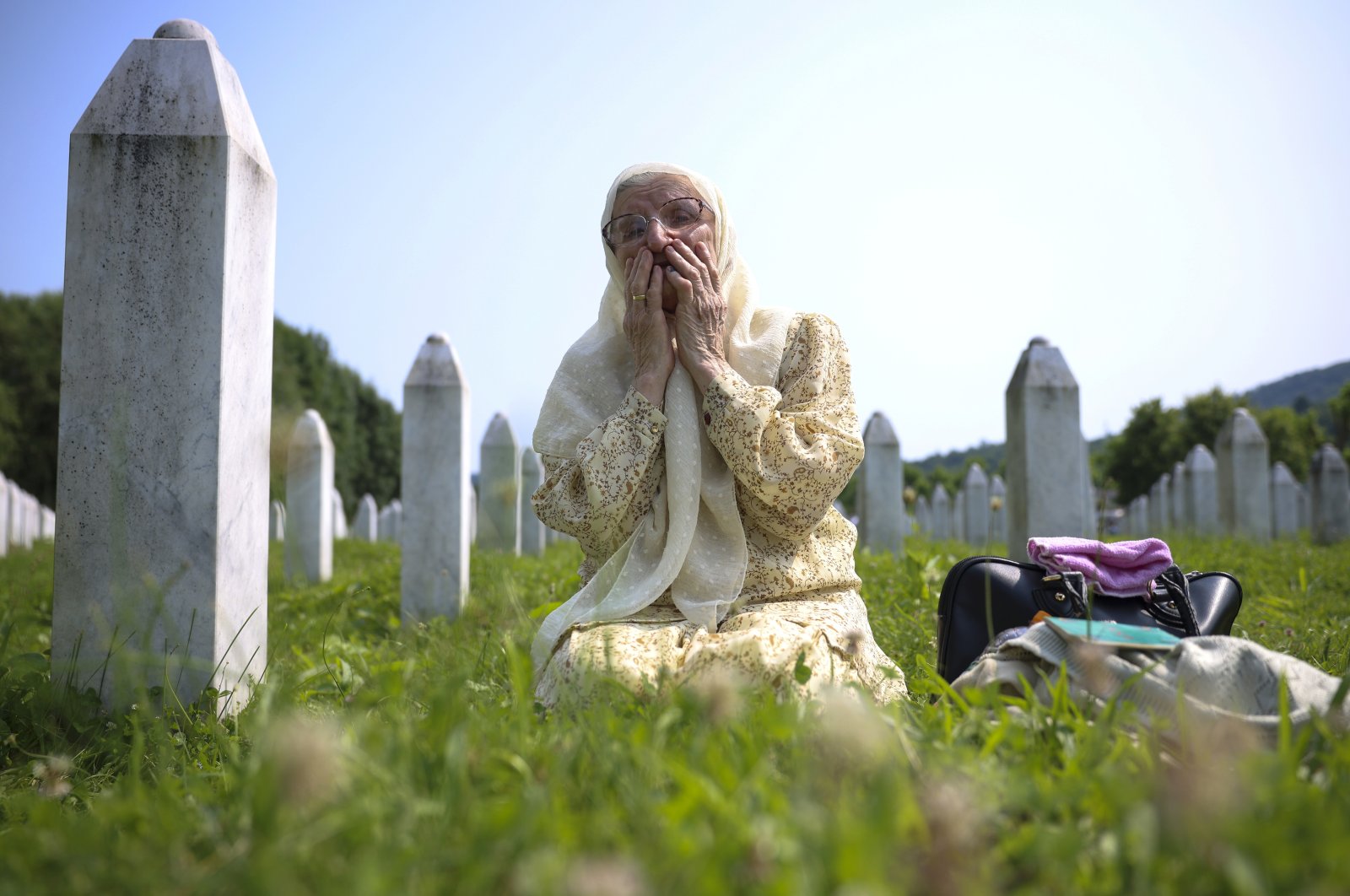 A Bosnian Muslim woman mourns next to the grave of her relative, victim of the Srebrenica genocide, at the Memorial Center in Potocari, Bosnia-Herzegovina, July 11, 2023. (AP Photo)