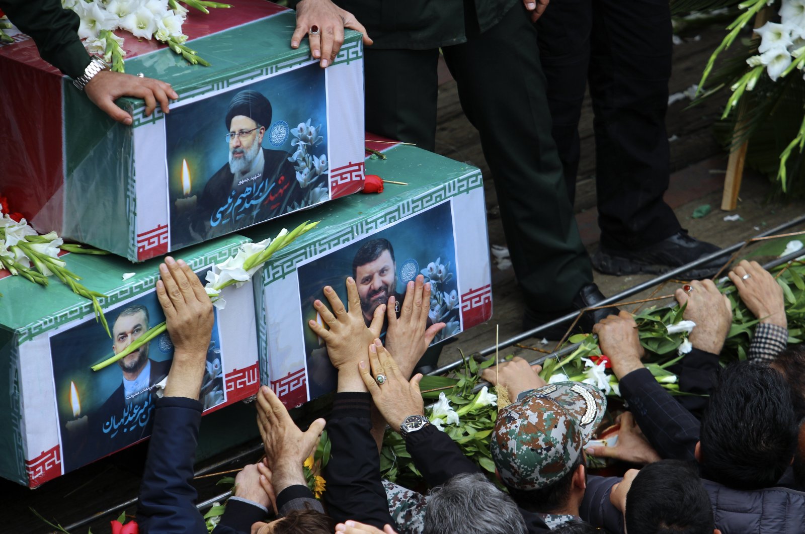 Mourners try to touch the coffins of Iranian President Ebrahim Raisi (top), Foreign Minister Hossein Amirabdollahian (L) and Raisi&#039;s chief bodyguard Gen. Mehdi Mousavi, who were killed in a helicopter crash on Sunday in a mountainous region of the country&#039;s northwest, during a funeral ceremony in the city of Tabriz, Iran, May 21, 2024. (AP Photo)