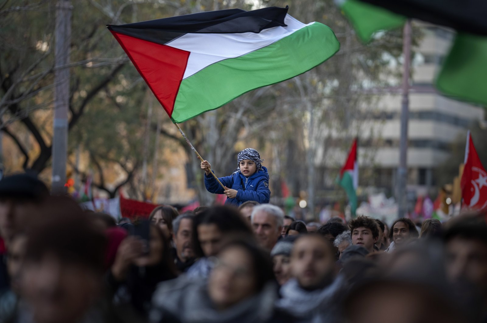 A boy waves a Palestinian flag as demonstrators march in support of Palestinians, in Barcelona, Spain, Jan. 20, 2024. (AP Photo)