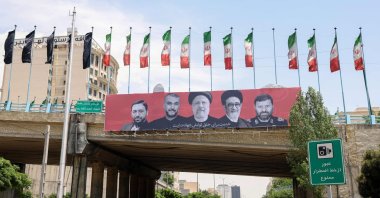Cars drive past a billboard bearing a portrait of Iran&#039;s late president Ebrahim Raisi (C), his foreign minister Hossein Amirabdollahian (2nd L) and other members of his entourage in central Tehran, Iran, May 21, 2024. (AFP Photo)
