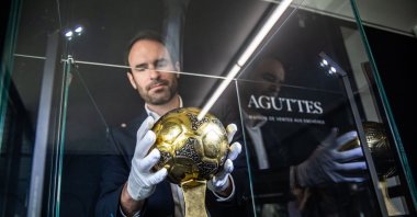 Francois Thierry, the sports expert at Aguttes auction house, installs the Diego Maradona's Golden Ball trophy in the case display, the trophy awarded to best player of the 1986 Football World Cup in Neuilly, Paris, France, May 13, 2024. (EPA Photo)
