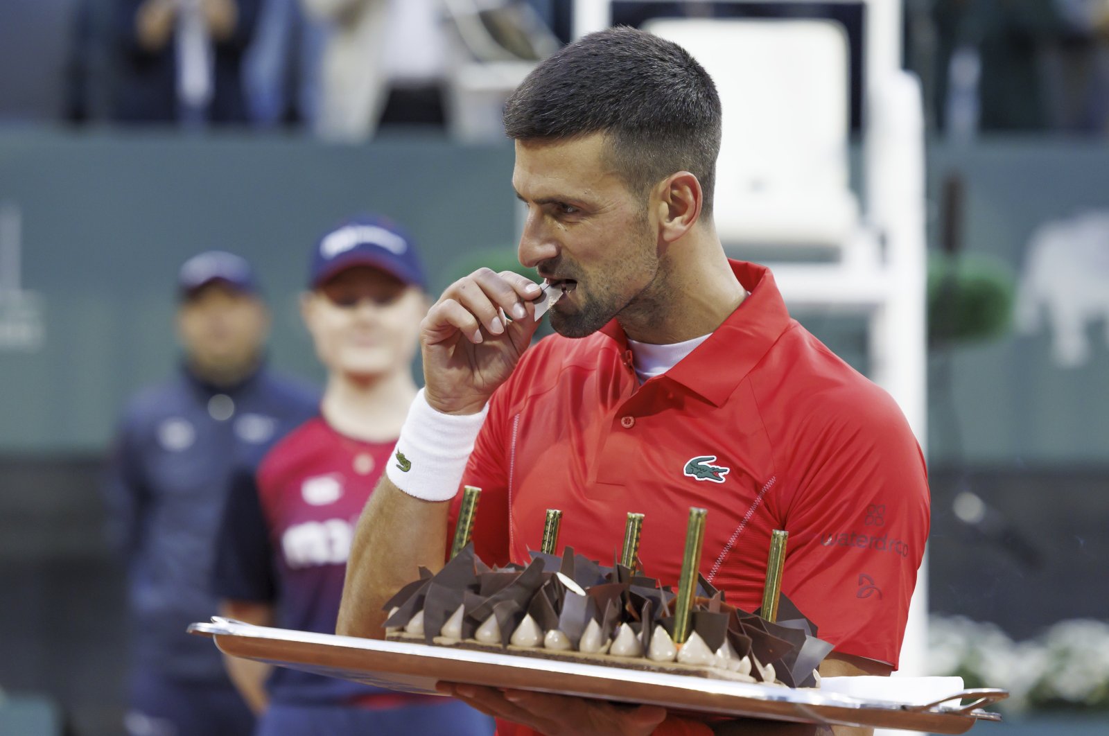 Serbia&#039;s Novak Djokovic tastes his birthday cake after he won his second round match of the ATP 250 Geneva Open tennis tournament against Germany&#039;s Yannick Hanfmann, Geneva, Switzerland, May 22, 2024. (AP Photo)