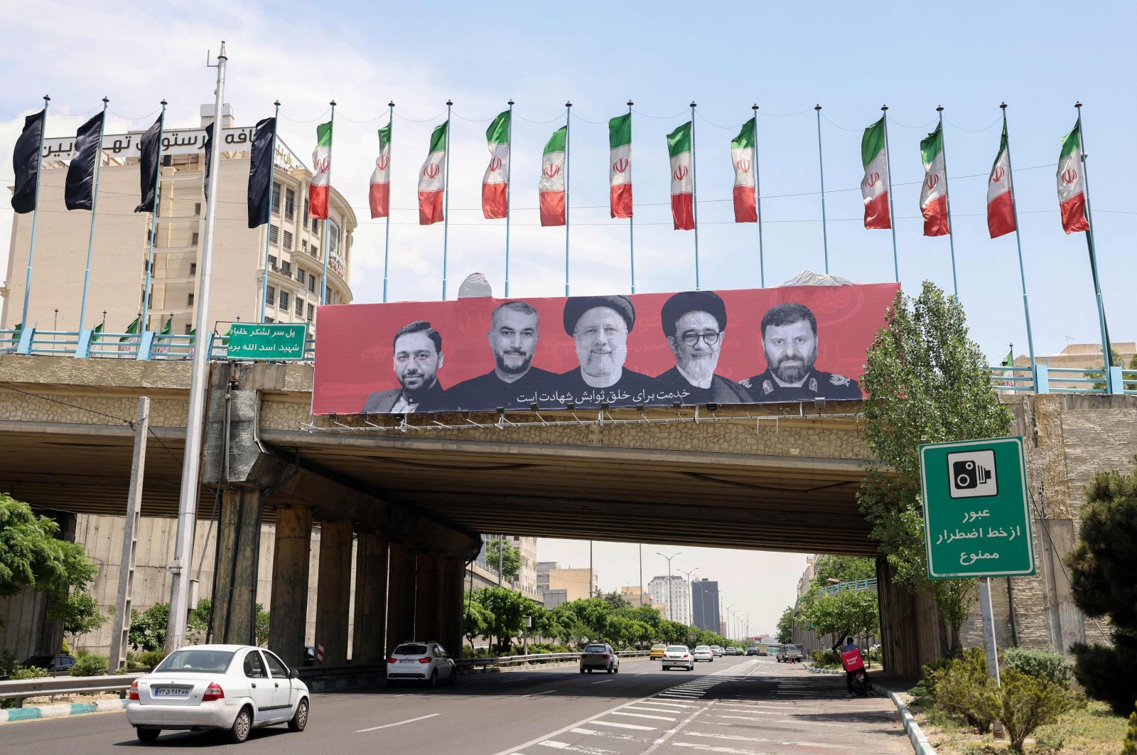 Cars drive past a billboard bearing a portrait of Iran&#039;s late president Ebrahim Raisi (C), his foreign minister Hossein Amirabdollahian (2nd L) and other members of his entourage in central Tehran, Iran, May 21, 2024. (AFP Photo)