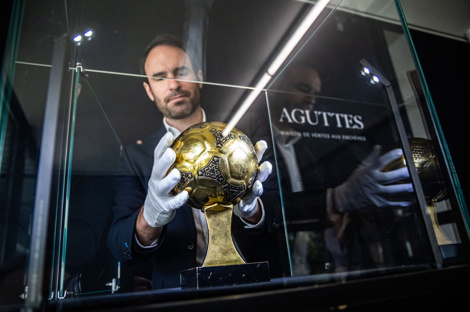 Francois Thierry, the sports expert at Aguttes auction house, installs the Diego Maradona&#039;s Golden Ball trophy in the case display, the trophy awarded to best player of the 1986 Football World Cup in Neuilly, Paris, France, May 13, 2024. (EPA Photo)