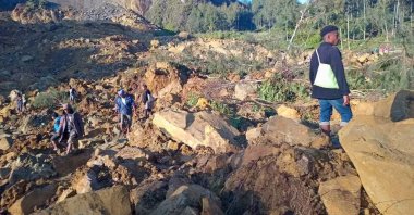 People walk with their belongings in the area where a landslide hit the village of Kaokalam, Enga province, Papua New Guinea, May 24, 2024. ()